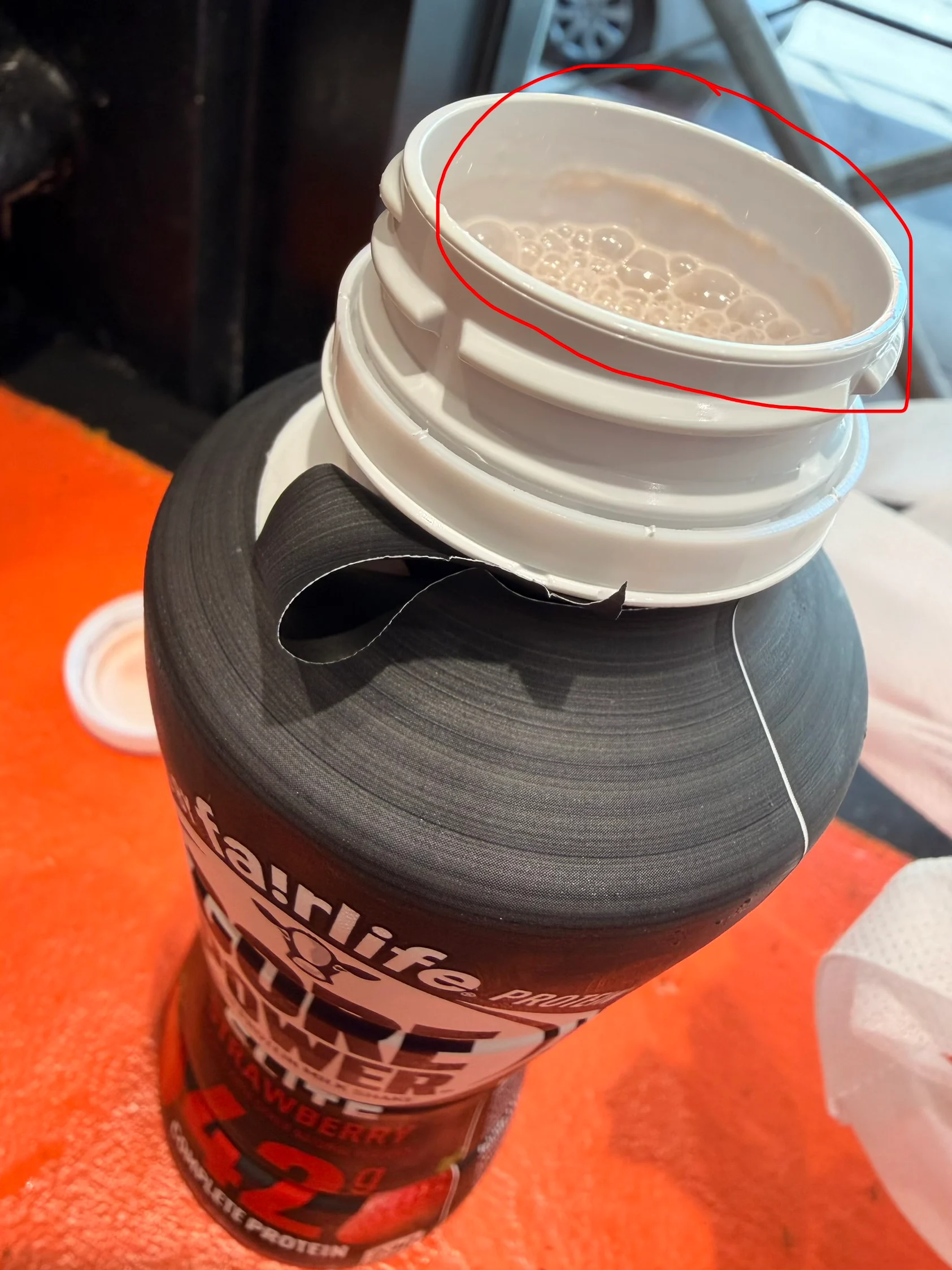 Pale residue around the inside neck of my strawberry Core Power bottle, circled in red.